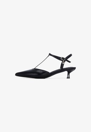 Zapato slingback de cuero negro con punta puntiaguda, diseño de tira en T y pequeño tacón kitten. Cuenta con una correa al tobillo con hebilla y textura suave.