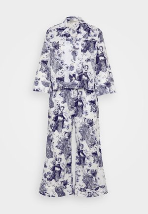 Conjunto de pijama branco feito de um tecido suave, apresentando um padrão floral e de figuras em azul-marinho. A parte de cima tem um decote com colarinho e mangas largas; as calças são de perna larga.