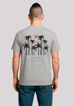 Gray cotton t-shirt featuring a black palm tree graphic and an orange sun, with the text “ESCAPE AND DISCOVER THE WORLD” below.