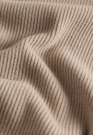 Beežikas soonikkangas pehme tekstuuriga, millel on vertikaalsed triibud ja nõtked niidi tiheduse variatsioonid, luues hubase ilme.