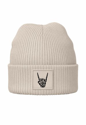 Beige knit beanie with a ribbed texture and a fold-over cuff featuring a black patch displaying a skeleton hand making a "rock on" gesture.