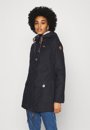 Navy parka jacket with a hood, front zipper, and button closure. Features brown accents and pockets on the front. Textured fabric.