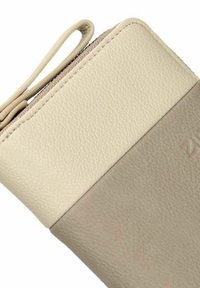 Portafoglio in pelle beige con una texture liscia, caratterizzato da una chiusura con zip e una sezione inferiore di un beige più scuro in contrasto. Design minimalista.