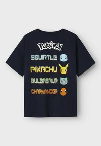 Tume sinine puuvillane T-särk, millel on sõna "Pokémon" ja Squirtle'i, Pikachu, Bulbasauri ja Charmanderi graafika elavate värvidega.