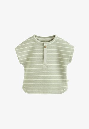 Jasnozielony top z krótkim rękawem w białe poziome paski, z detalem w postaci guzika i zaokrąglonym dołem dla luźniejszego kroju.