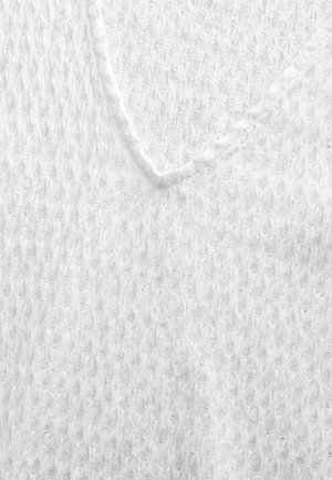 Suéter blanco de punto con un diseño de escote en V, que presenta un patrón texturizado similar a un gofre. La tela parece suave y ligera.