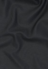 Σκούρο γκρι ύφασμα με διακριτική διαγώνια υφή ύφανσης και απαλά διπλώματα που δημιουργούν απαλές σκιές και φωτεινές ανταύγειες.