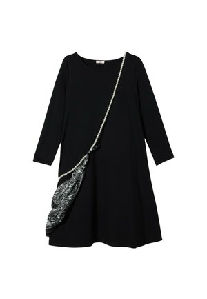 Czarna sukienka z długim rękawem o luźnym kroju, z wzorzystą czarno-białą torbą na ramię ozdobioną paskiem z pereł.