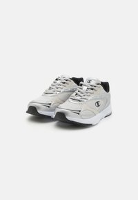 Lehké sportovní boty v bílé a stříbrné síťovině, s černými akcenty, kulatými tkaničkami a polstrovanou podrážkou pro pohodlí.