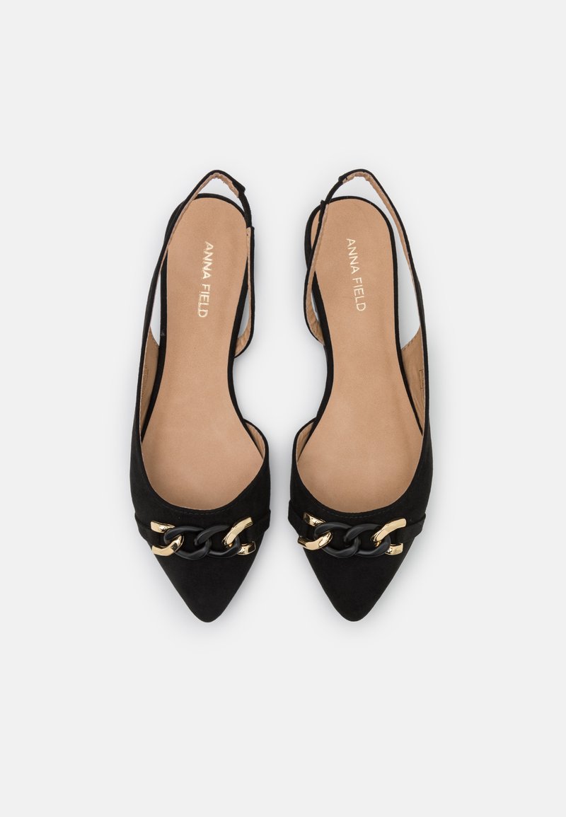 Schwarze Wildleder-Ballettschuhe mit spitzem Zehenbereich, ausgestattet mit einer goldenen und schwarzen Kettenakzentierung an der Vorderseite und einem ausgeschnittenen Design an der Seite.