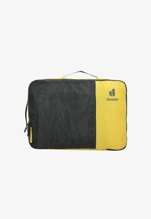 Cube de voyage Deuter en nylon noir et jaune, avec fermeture zippée, poignée de transport et panneau en mesh pour la visibilité.