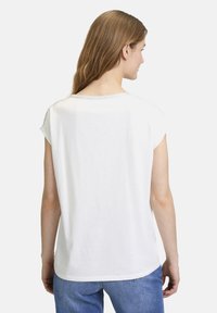 T-shirt blanc à manches courtes avec un col rond et une texture douce, présentant un design simple et une coupe droite à l'ourlet.