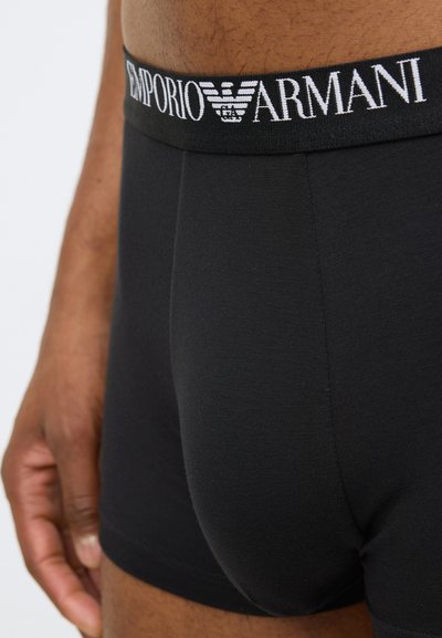Μαύρα ανδρικά μποξεράκια από βαμβάκι με εφαρμοστή σχεδίαση. Διαθέτουν ελαστική μέση με το λογότυπο "Emporio Armani" σε λευκό. Μαλακή υφή, λεία επιφάνεια.