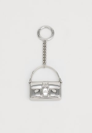 Porte-clés en argent en forme de sac à main, avec un design structuré, une surface métallique brillante et un attachement en chaîne.