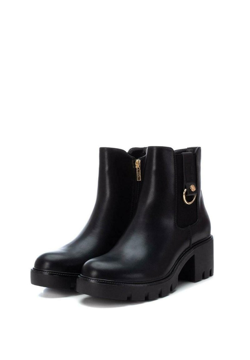 Schwarze Lederankelstiefel mit einem blockartigen Absatz, seitlichem Reißverschluss und elastischen Einsätzen. Mit einem goldenen Akzentring an der Seite.