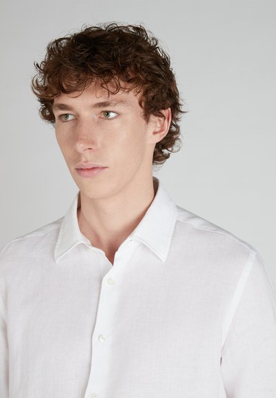White linen button-up shirt with a classic collar, featuring a lightweight texture and subtle wrinkles for a relaxed look.