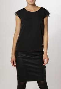 Haut noir à manches courtes avec bordure en dentelle, associé à une jupe crayon en cuir noir ajustée. Texture lisse, design simple et coupe cintrée.