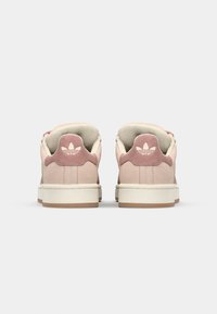 Růžové semišové tenisky s bílými akcenty, vybavené texturovaným podpatkem a logem, gumovou podrážkou a polstrovaným límcem pro pohodlí.