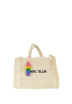 Sac cabas tissé beige avec côtés à franges, décoration colorée de pompons et texte "MARC ELLIS" imprimé sur le devant.