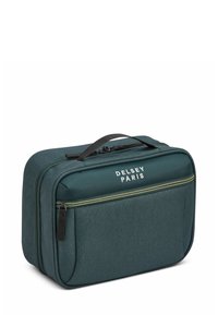 Bolso de viaje de textil verde oscuro con doble cremallera, logotipo "Delsey Paris" y un mango resistente. Forma rectangular con una textura suave.