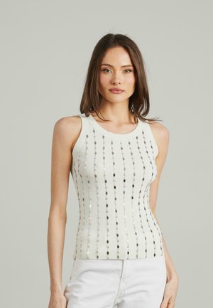 Canotta bianca a righe con accenti verticali di paillettes argento. Il tessuto presenta un design aderente con spalline larghe e scollatura rotonda.