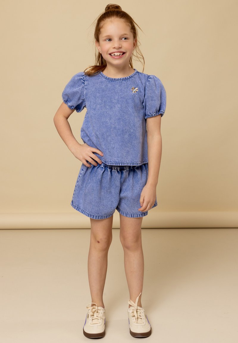 Lichtblauwe denim twee-delige outfit met een top met pofmouwen en bijpassende shorts met elastische tailleband en gestikte details.