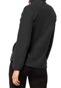 Svart fleecejacka med hög krage och sidofickor. Tillverkad av mjukt material med en slät textur och minimalistisk design.