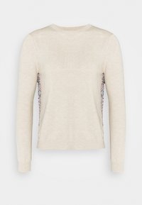 Cremfarbener Pullover mit langen Ärmeln, der eine strukturierte Strickfront und einen floral gemusterten Stoff an den Seiten hat. Rundhalsausschnitt und eng anliegende Bündchen.