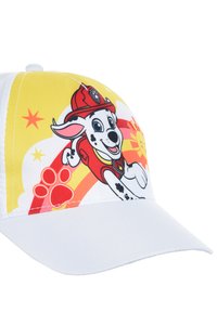 Cappello bianco con una grafica colorata di un cane dei cartoni animati che indossa un cappello da pompiere rosso, su uno sfondo giallo e con colori vivaci.