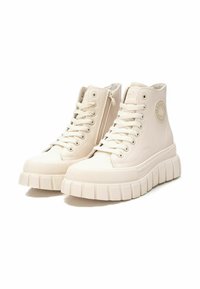 Zapatillas altas de material sintético color blanco roto, con cierre de cordones en la parte delantera, cremallera lateral, suela de goma texturizada y detalle de logo en relieve.