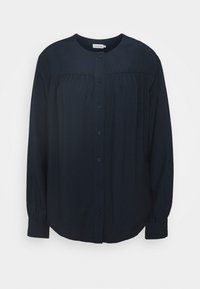 Blusa lunga a maniche con scollo rotondo di un blu navy scuro, bottoni frontali, motivo testurizzato sottile e dettagli con yoke arricciata.