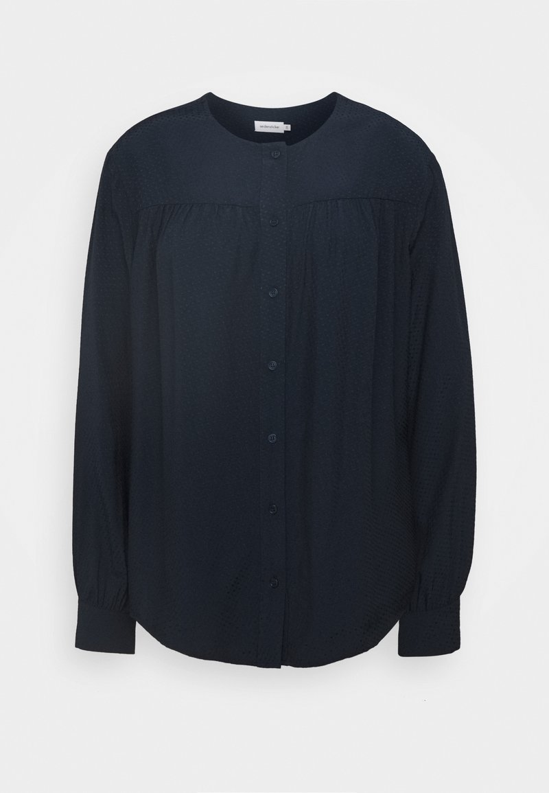 Blusa lunga a maniche con scollo rotondo di un blu navy scuro, bottoni frontali, motivo testurizzato sottile e dettagli con yoke arricciata.