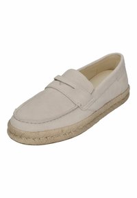 Beige suède instap-schoenen met een gestikt moccasin-stijl bovenwerk en een gevlochten jute zool. Soepele textuur, minimalistisch ontwerp en geen zichtbare hardware.