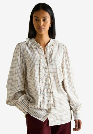 Button-up shirt made of lightweight fabric, featuring a ruffled collar, plaid pattern in pastel colors, and long, slightly puffed sleeves.