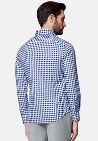 Koszula z długim rękawem w niebiesko-białą kratę, z kołnierzykiem zapinanym na guziki oraz zaokrąglonym dołem, wykonana z lekkiego materiału.