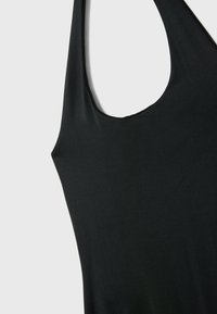 Černý bezramínkový top s výstřihem do lodi a hladkou, jemnou texturou. Tkanina má mírný lesk a jednoduchý, minimalistický design.