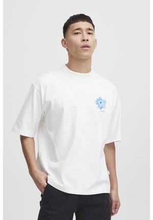Hvid bomulds T-shirt med korte ærmer, med et blåt blomstermotiv på venstre side og rund halsudskæring. Enkel design, afslappet pasform.