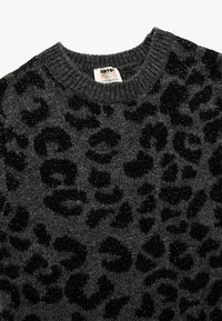 Grå sweater med et sort leopardprintmønster, lavet af et blødt, tekstureret materiale. Har en ribbestrikket halsudskæring.