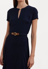 Abito blu navy a maniche corte con scollatura a chiave e dettagli dorati. Presenta una cintura in pelle marrone con hardware dorato in vita. Tessuto morbido.