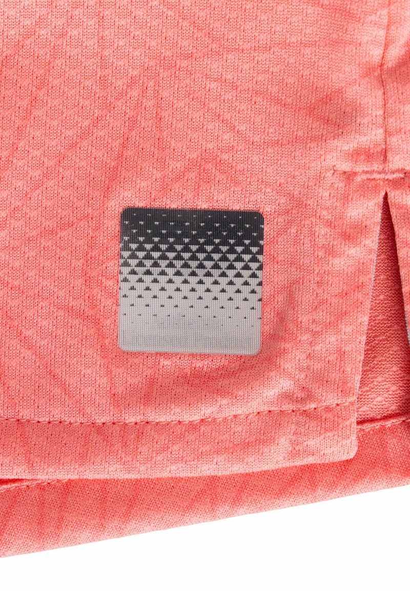 Korallenfarbiger Stoff mit einer strukturierten Musterung, der eine silberne quadratische Marke mit einem Farbverlauf und kleinen schwarzen Punkten in der unteren rechten Ecke zeigt.