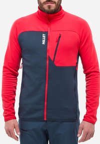 Herren Fleecejacke mit rotem oberen Bereich und marineblauem unteren Abschnitt, durchgehendem Reißverschluss, Brusttasche und kontrastierenden Reißverschlussakzenten.