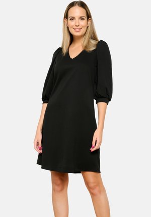 Robe noire avec un col en V, des manches bouffantes et une coupe décontractée. Tissu lisse avec un ourlet au niveau du genou. Design simple et moderne.