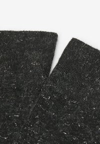 Zwarte gebreide sokken met een zachte textuur, voorzien van zilveren draadaccenten en een licht fuzzy uitstraling. Twee overlappende manchetten zijn zichtbaar.