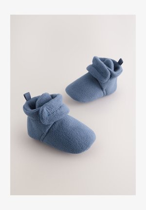 Scarpette azzurre in pile con risvolto e linguetta per indossarle facilmente. Texture morbida e design con punta arrotondata. Adatte all'uso interno.