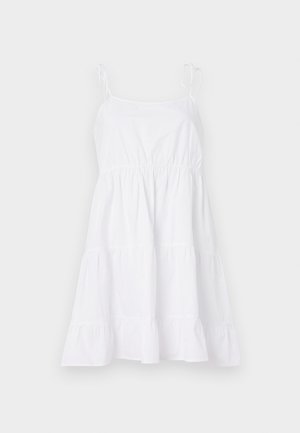 Λευκό βαμβακερό φόρεμα με λεπτές τιράντες, εφαρμοστό μπούστο και φούστα με στρώσεις. Το ύφασμα είναι απαλό με ελαφριά, αέρινη υφή.