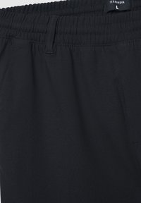 Pantaloni della tuta neri con vita elastica, caratterizzati da una texture liscia e una tasca laterale. Etichetta con la scritta "Terranova", taglia L.