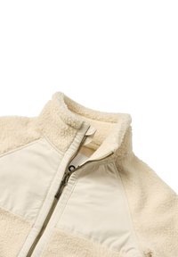 Giacca in pile crema con colletto alto, zip frontale e pannelli di tessuto liscio su spalle e area del torace.