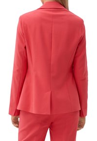 Blazer corail à la silhouette ajustée, avec des revers classiques et une fente dans le dos. Fabriqué dans un tissu lisse, conçu pour un look tailleur.