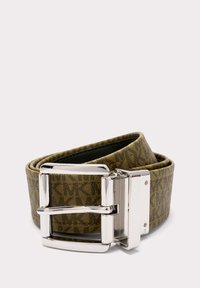 Ceinture brune à motif avec une boucle en métal argenté déroulée sur un fond clair.