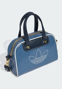 Sac à main en cuir bleu avec texture perforée, fermeture éclair dorée, deux poignées, une bandoulière amovible et logo brodé sur le devant.
